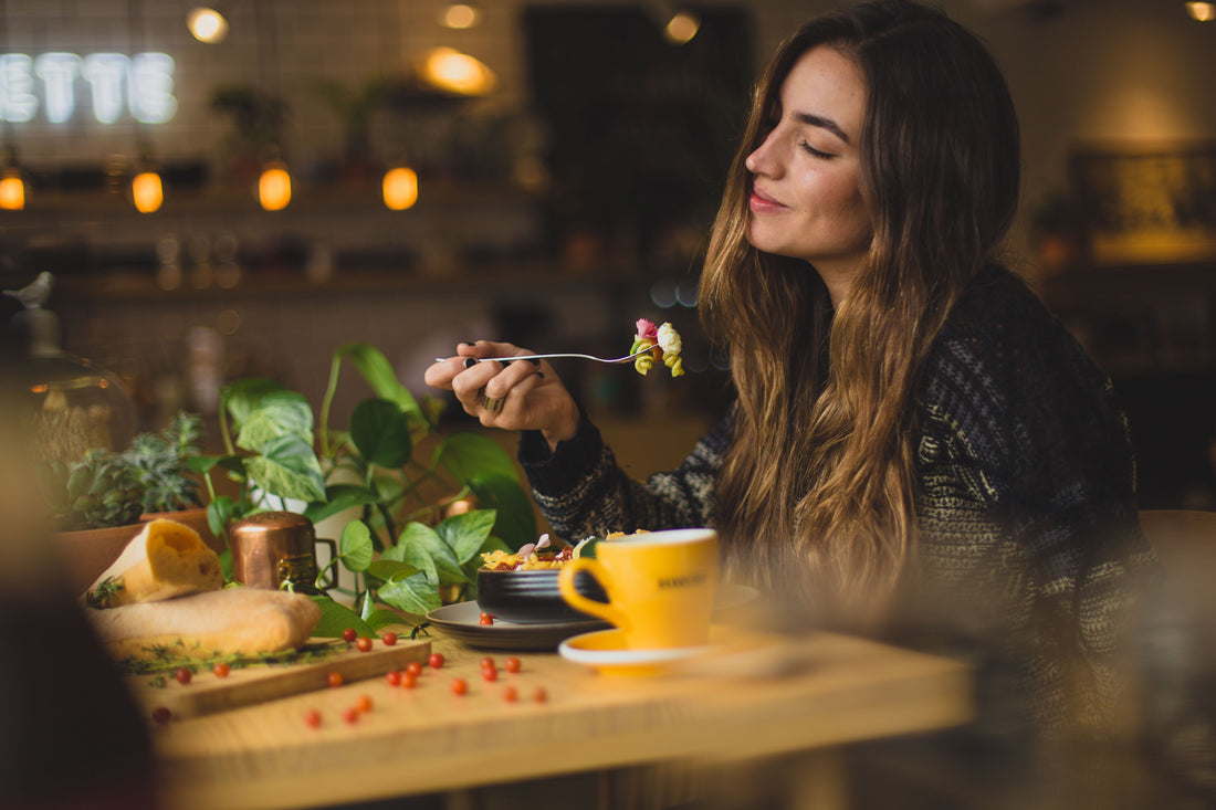 person smiling and eating whole foods alone photo by: Pablo Merchán Montes on Unsplash